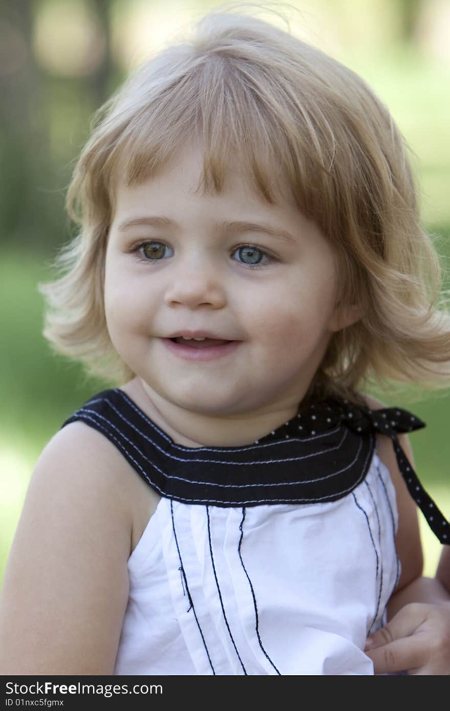 Little girl with blue and brown eyes outside