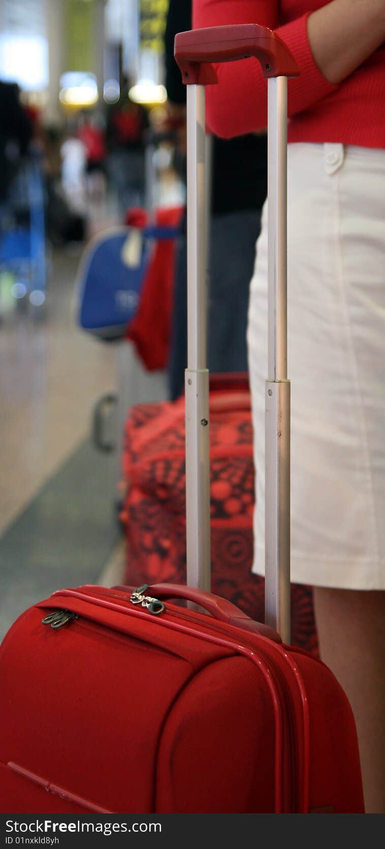 Lady in red traveling with matching red luggage.