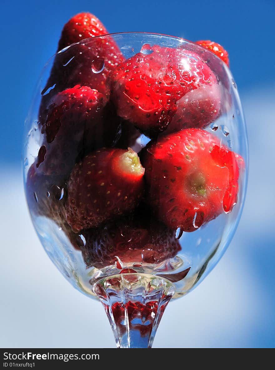 Strawberry in glass over blue sky