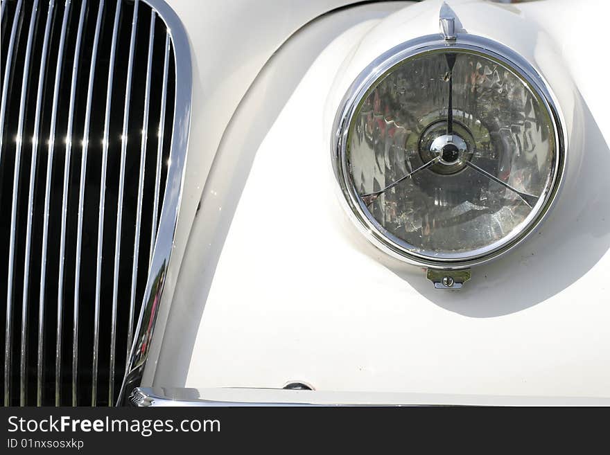 Front view of a chrome light and grill from an old vintage car. Front view of a chrome light and grill from an old vintage car.