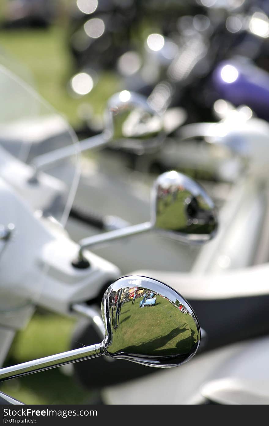 A group of scooter wing mirrors with the front one in focus. A group of scooter wing mirrors with the front one in focus.