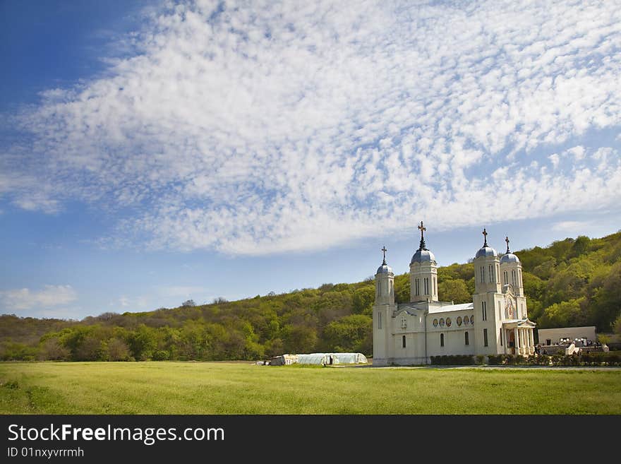 Monastery in plain in front of a forest