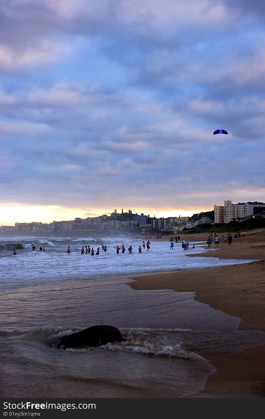 Sun bathers playing in the waves