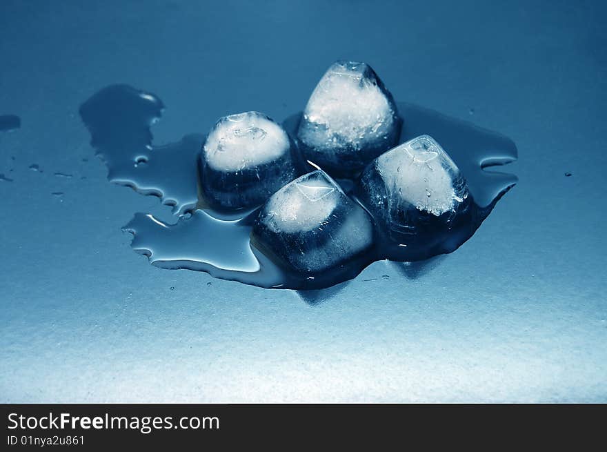 Colored Ice Cubes Melted In Water On Reflection