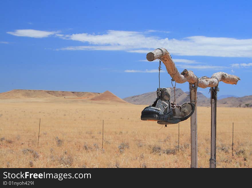 Couple of shoes hanging on a stick. Couple of shoes hanging on a stick.