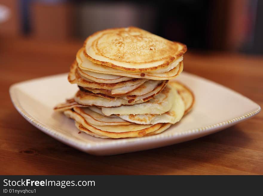 The newly-baked ruddy fritters which have been laid out by a pile on a plate (shallow DOF). The newly-baked ruddy fritters which have been laid out by a pile on a plate (shallow DOF)