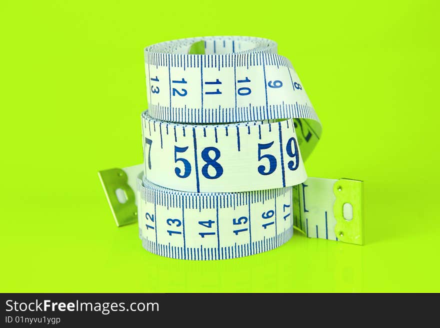 A measuring tape isolated against a lime green background. A measuring tape isolated against a lime green background