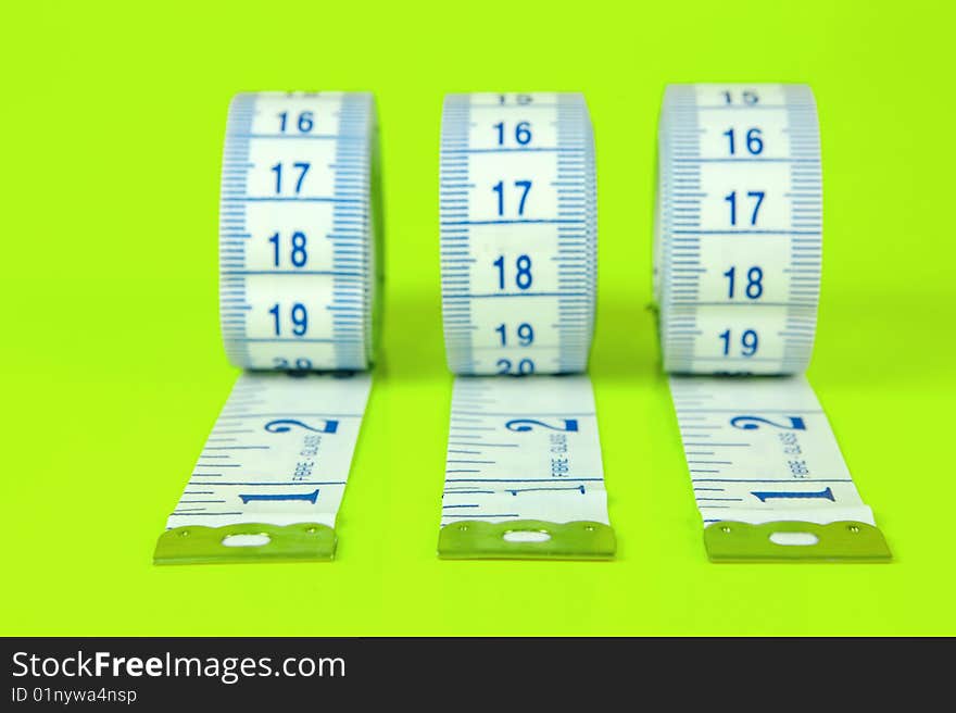 A measuring tape isolated against a lime green background. A measuring tape isolated against a lime green background