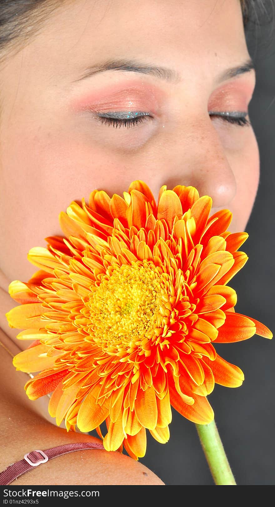 Shy girl with gerbera flower