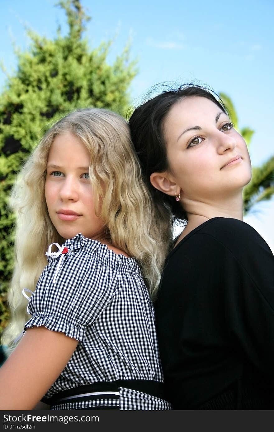 Pretty blond and brunette girls back to back. Pretty blond and brunette girls back to back.