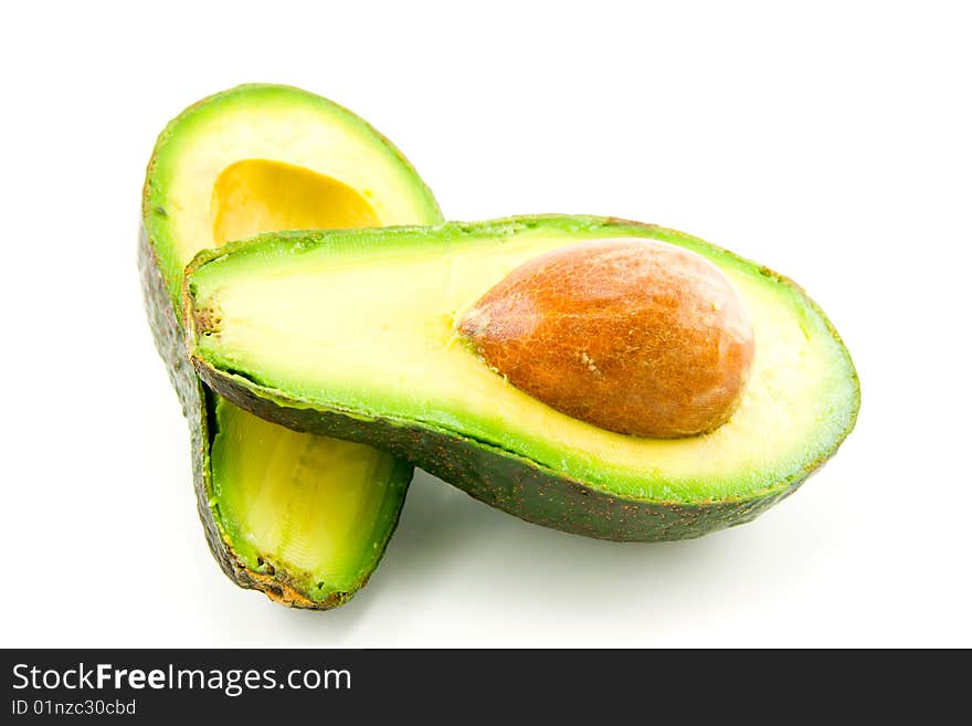 Single dark green avocado fruit split in half and showing the kernel on a white background. Single dark green avocado fruit split in half and showing the kernel on a white background