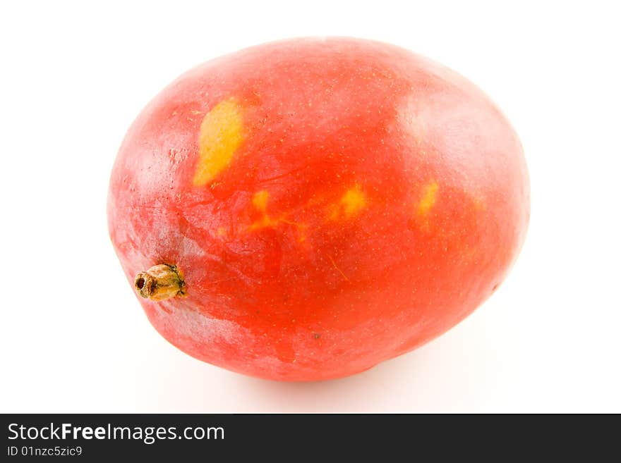 Single red and orange ripened mango fruit with a short stalk on a white background. Single red and orange ripened mango fruit with a short stalk on a white background