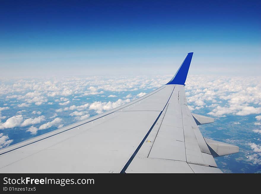 White wing airplane. Blue sky and white clouds.