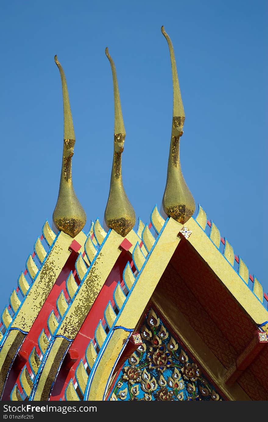 Three temple roofs against a blue sky