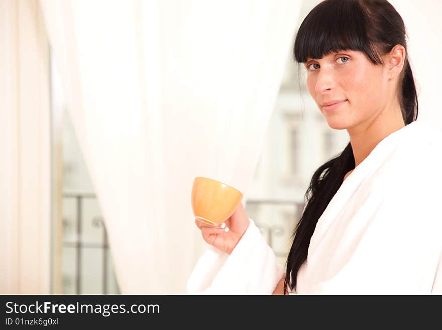 Woman standing on window with a cup of tea. Woman standing on window with a cup of tea