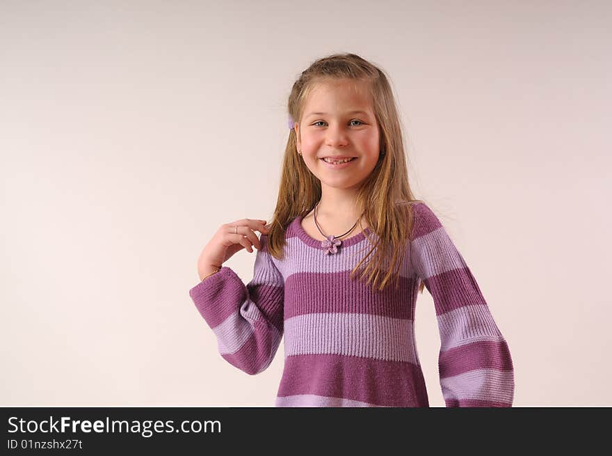 Close up with small, smiling girl with her hand in hair. Close up with small, smiling girl with her hand in hair