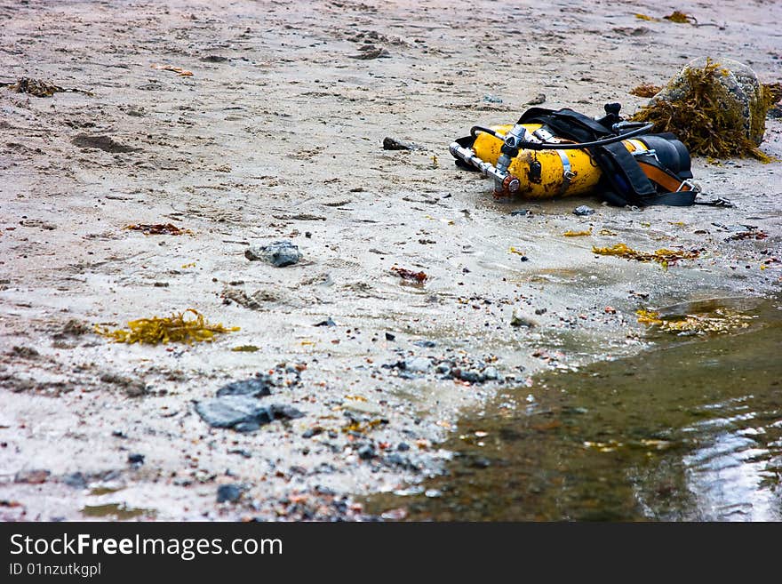 Yellow cylinders lying on sandy coast for diving