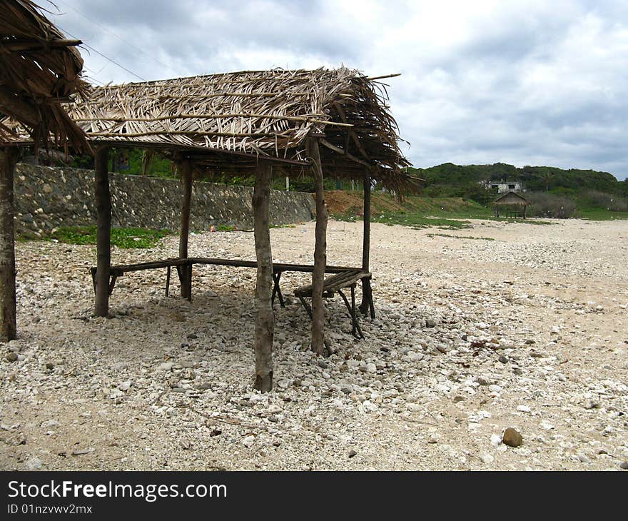 Old cottage made of indigenous materials on rocky shore