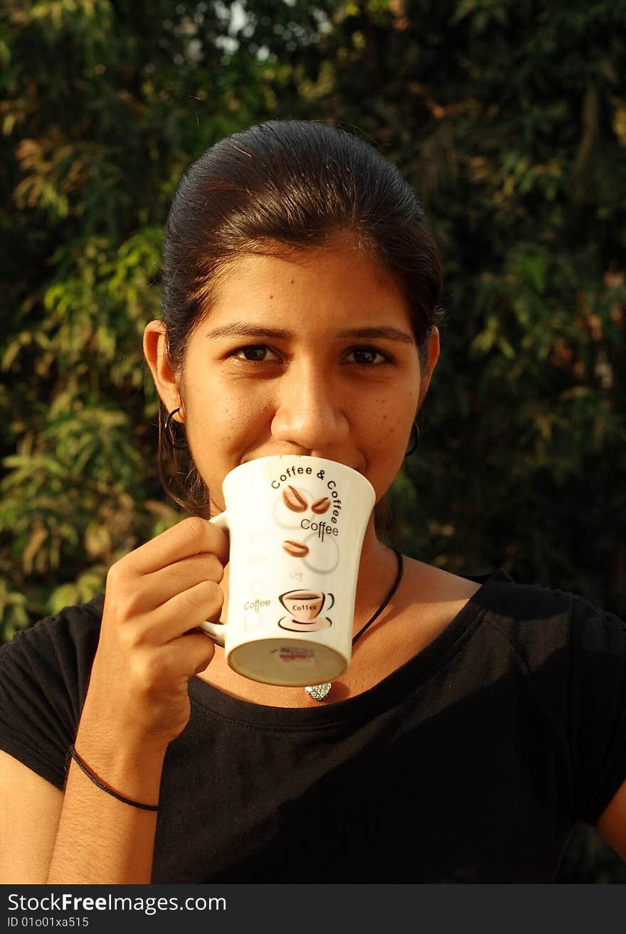 A girl drinking a hot coffee in the morning. A girl drinking a hot coffee in the morning.