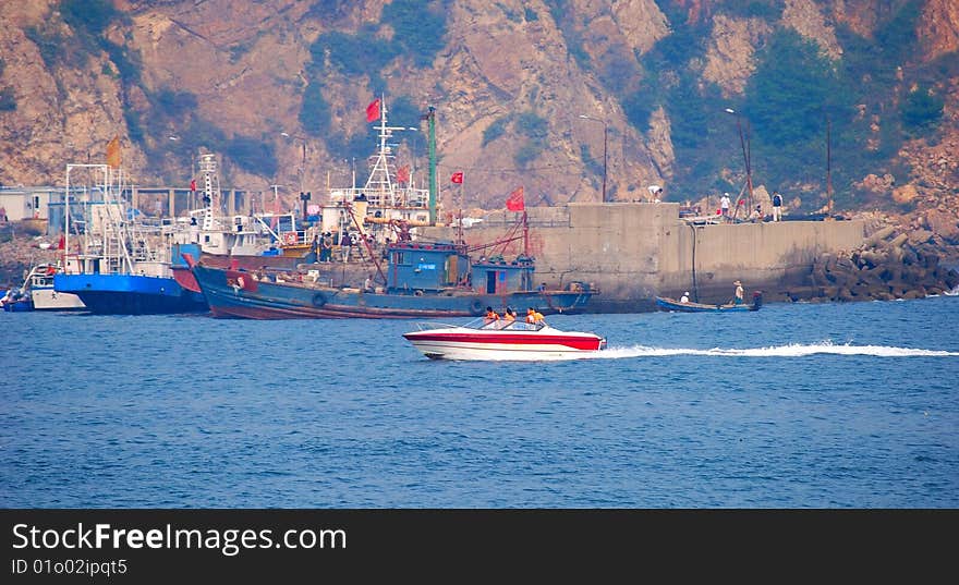 Port. Group of ships. Motorboat with rescues.