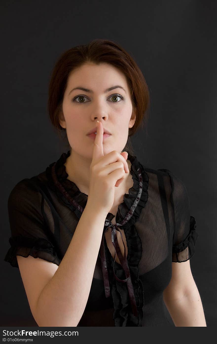 Beautiful young woman asking for silence, grey background. Beautiful young woman asking for silence, grey background.