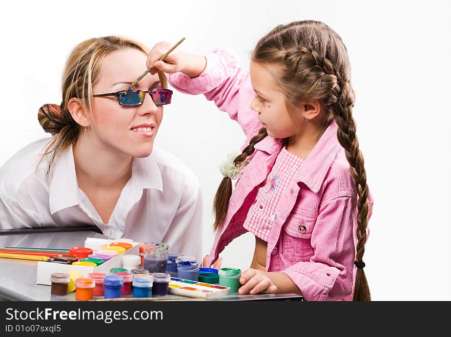 Adorable little girl painting mother's glasses. Adorable little girl painting mother's glasses