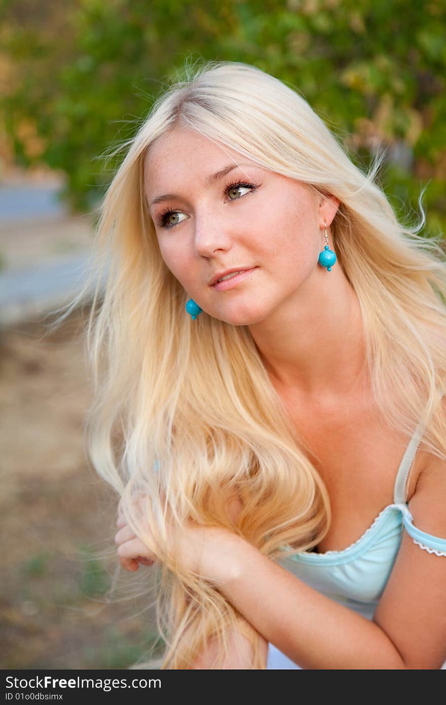 Lovely beautiful blonde woman against sunny outdoor greenery. Lovely beautiful blonde woman against sunny outdoor greenery