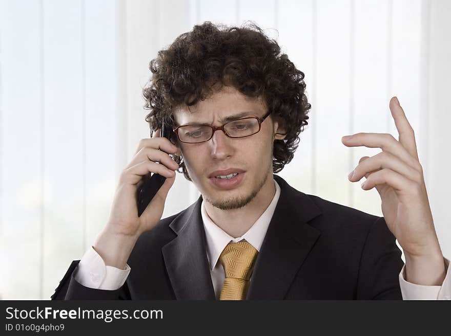 Angry businessmen explains in the phone in the office