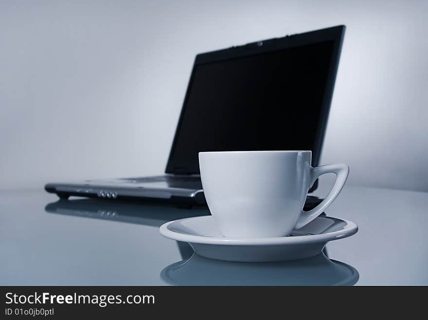 Cup of coffee and notebook in soft-focus