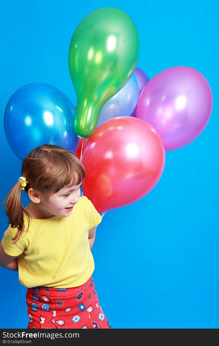 Little girl holding colorful balloons on a blue background. Little girl holding colorful balloons on a blue background