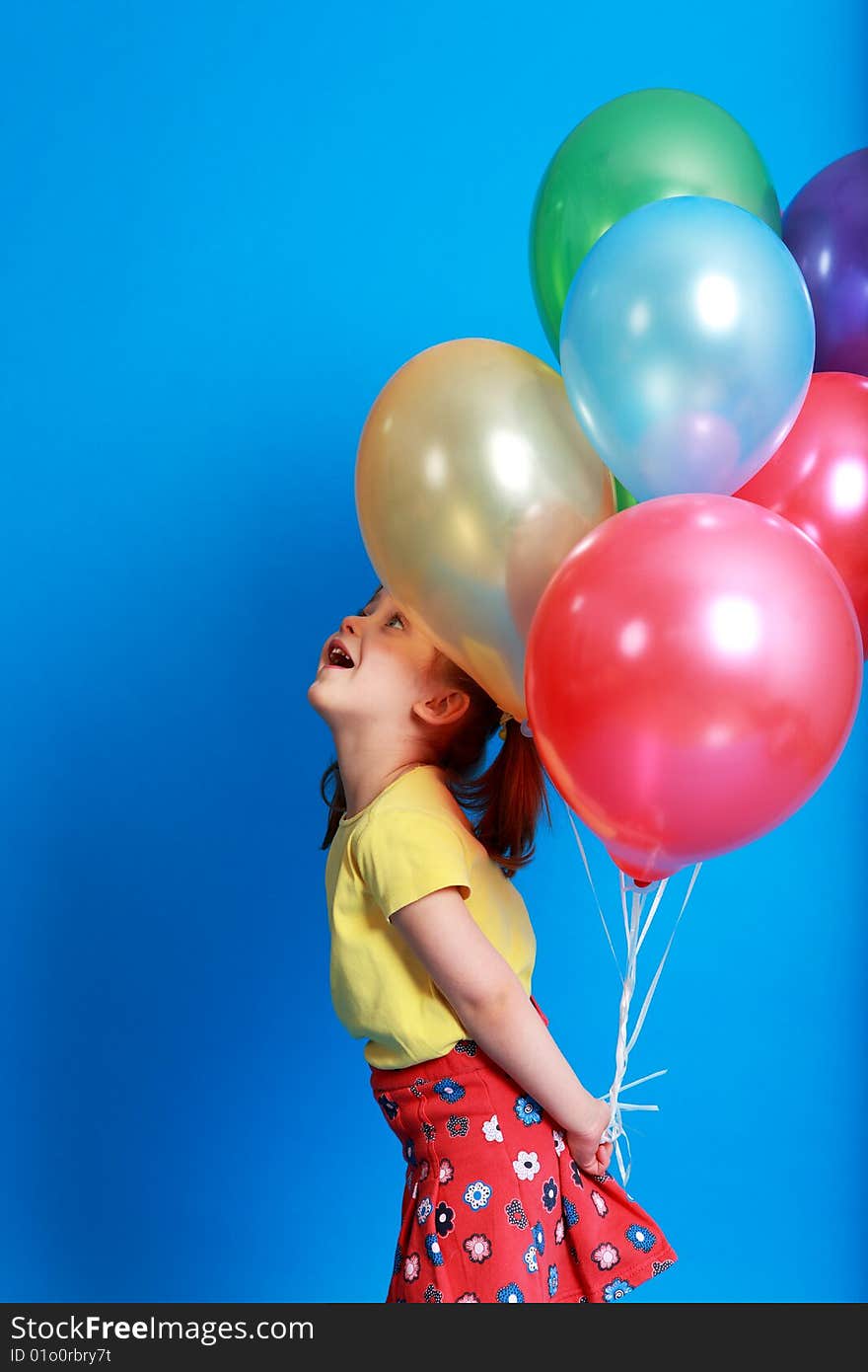 Little girl holding colorful balloons on a blue background. Little girl holding colorful balloons on a blue background