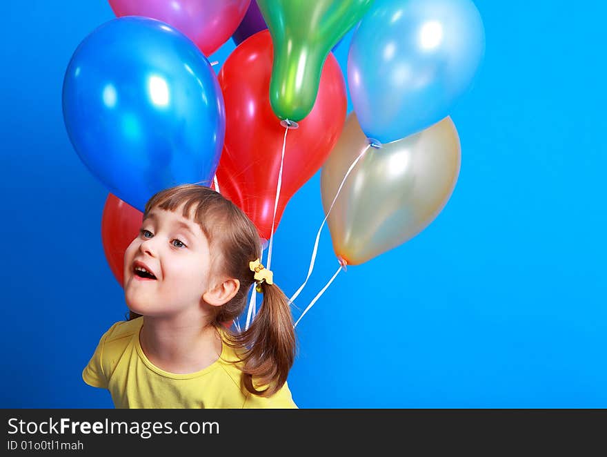 Little girl holding colorful balloons on a blue background