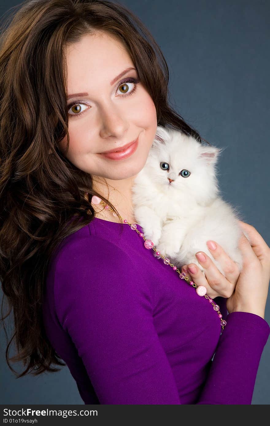 Beautiful girl in purple dress holding little whit