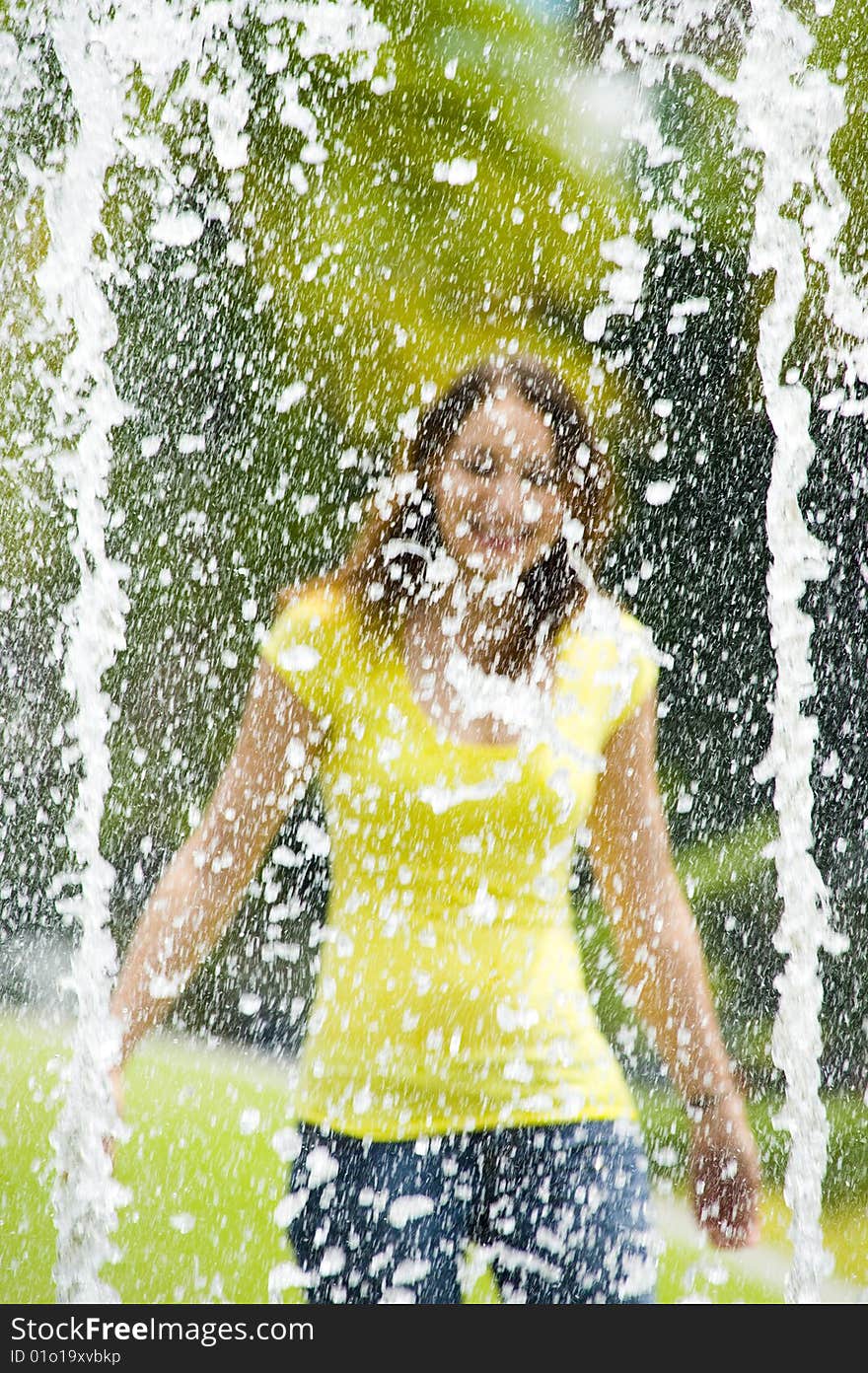 A young caucasian girl playing at fountain