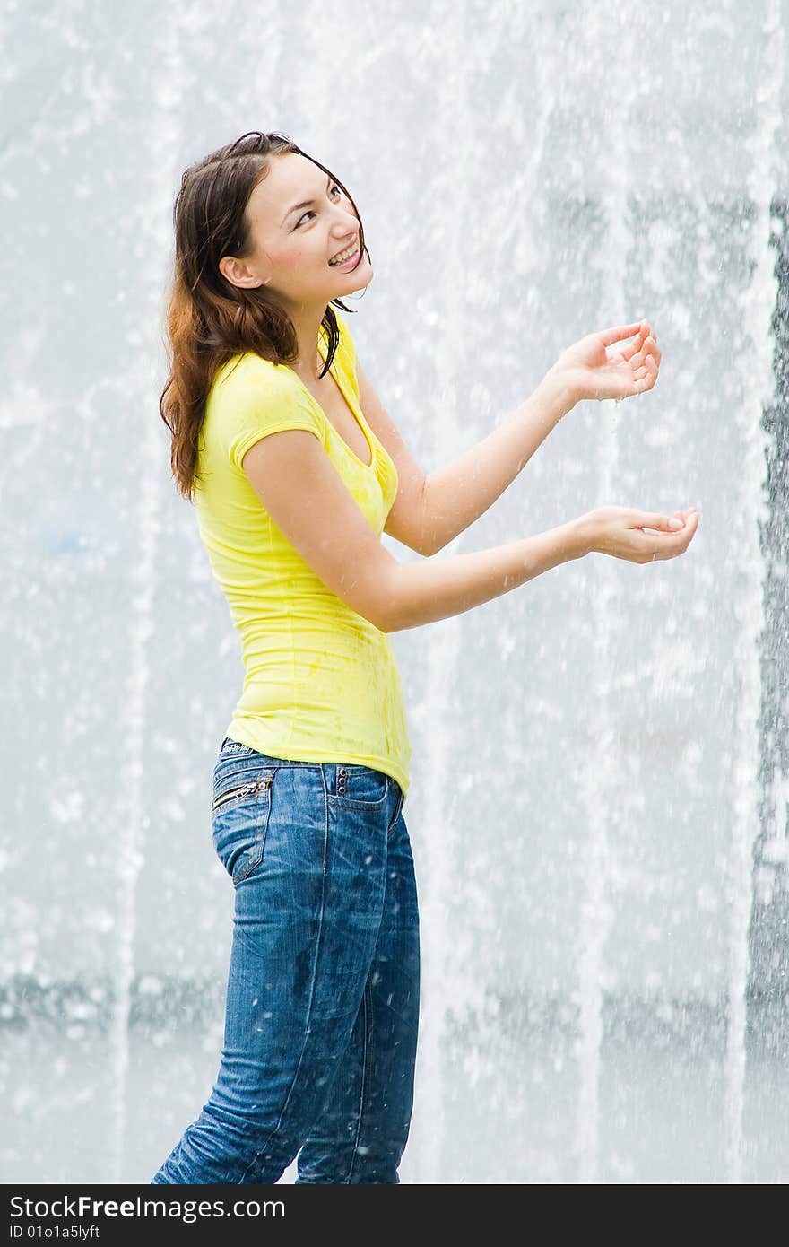 A young caucasian girl playing at fountain