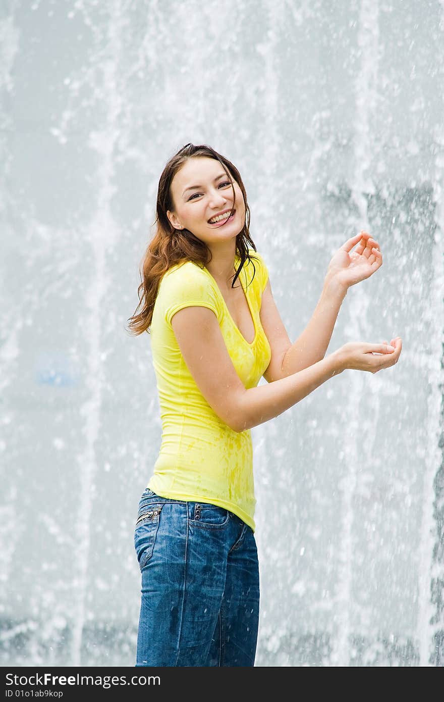 Young caucasian girl playing at fountain