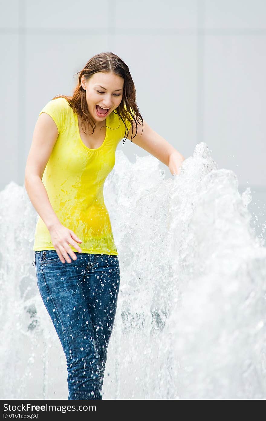 Young caucasian girl playing at fountain