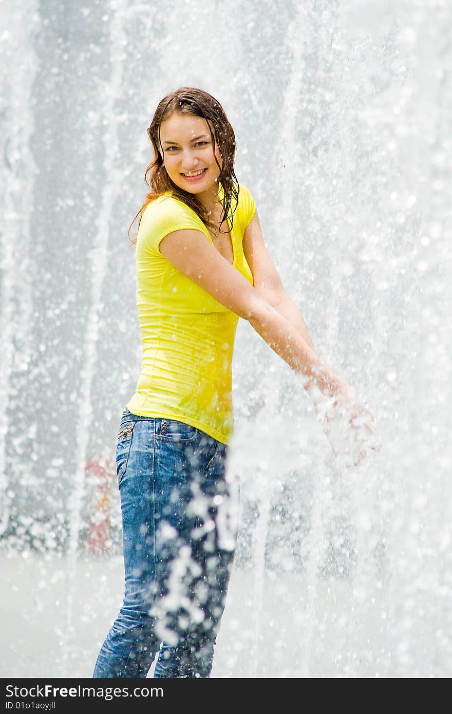 A young caucasian girl playing at fountain