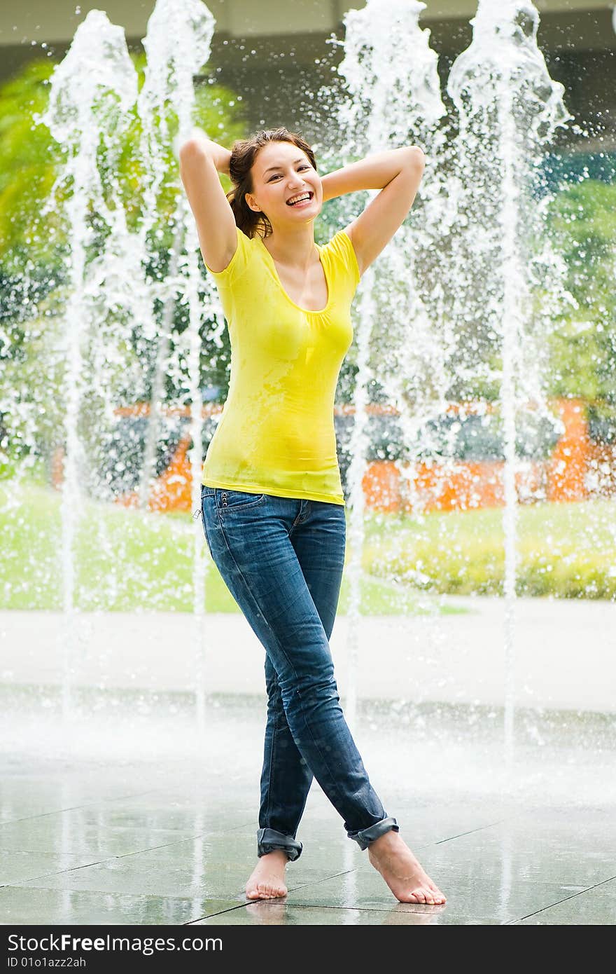 A young caucasian girl playing at fountain