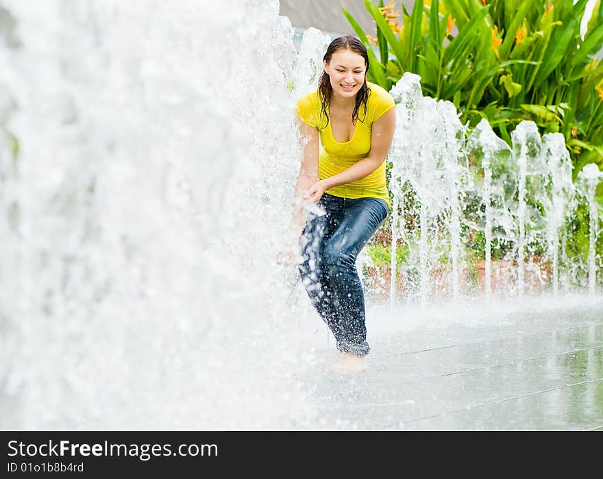 A young caucasian girl playing at fountain