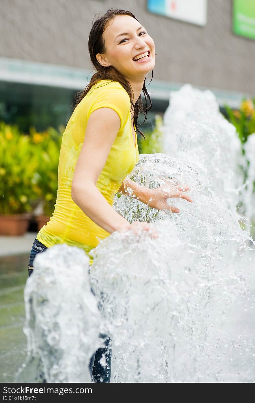 Young caucasian girl playing at fountain