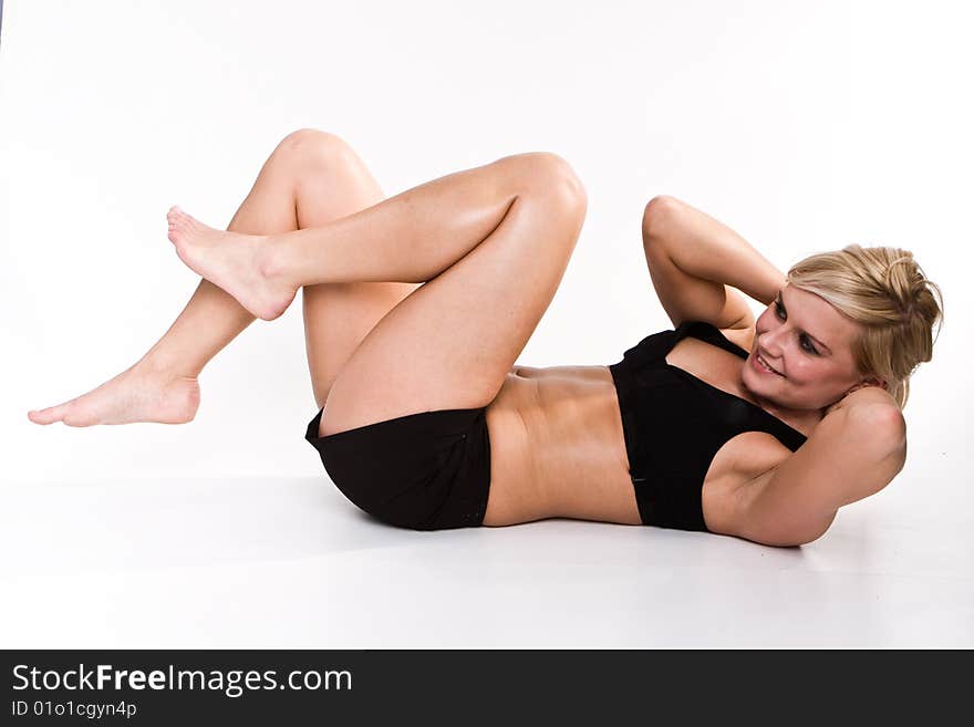 Beautiful young girl doing physical exercises on the floor. Beautiful young girl doing physical exercises on the floor