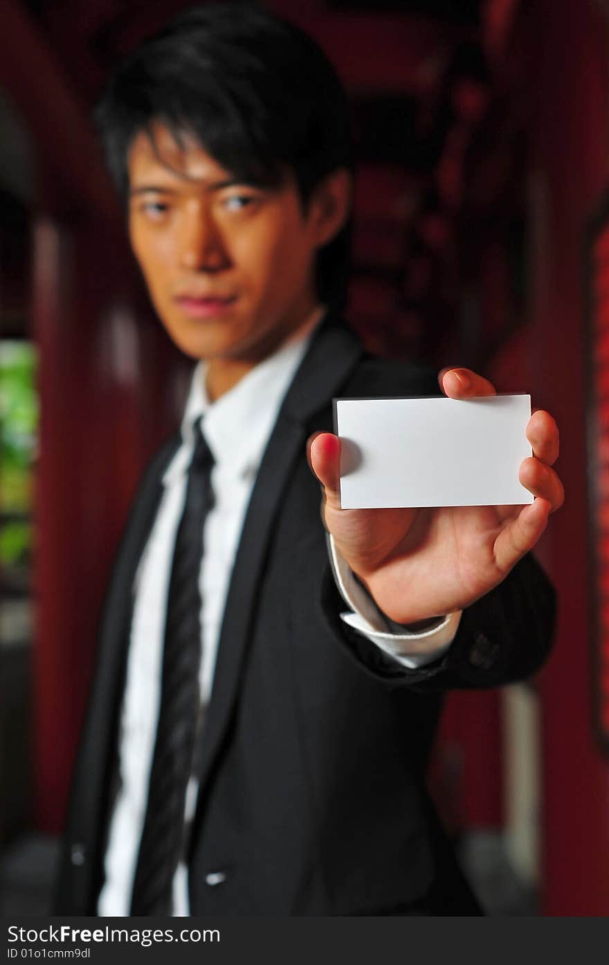 Asian man in business suit with blank card. Asian man in business suit with blank card