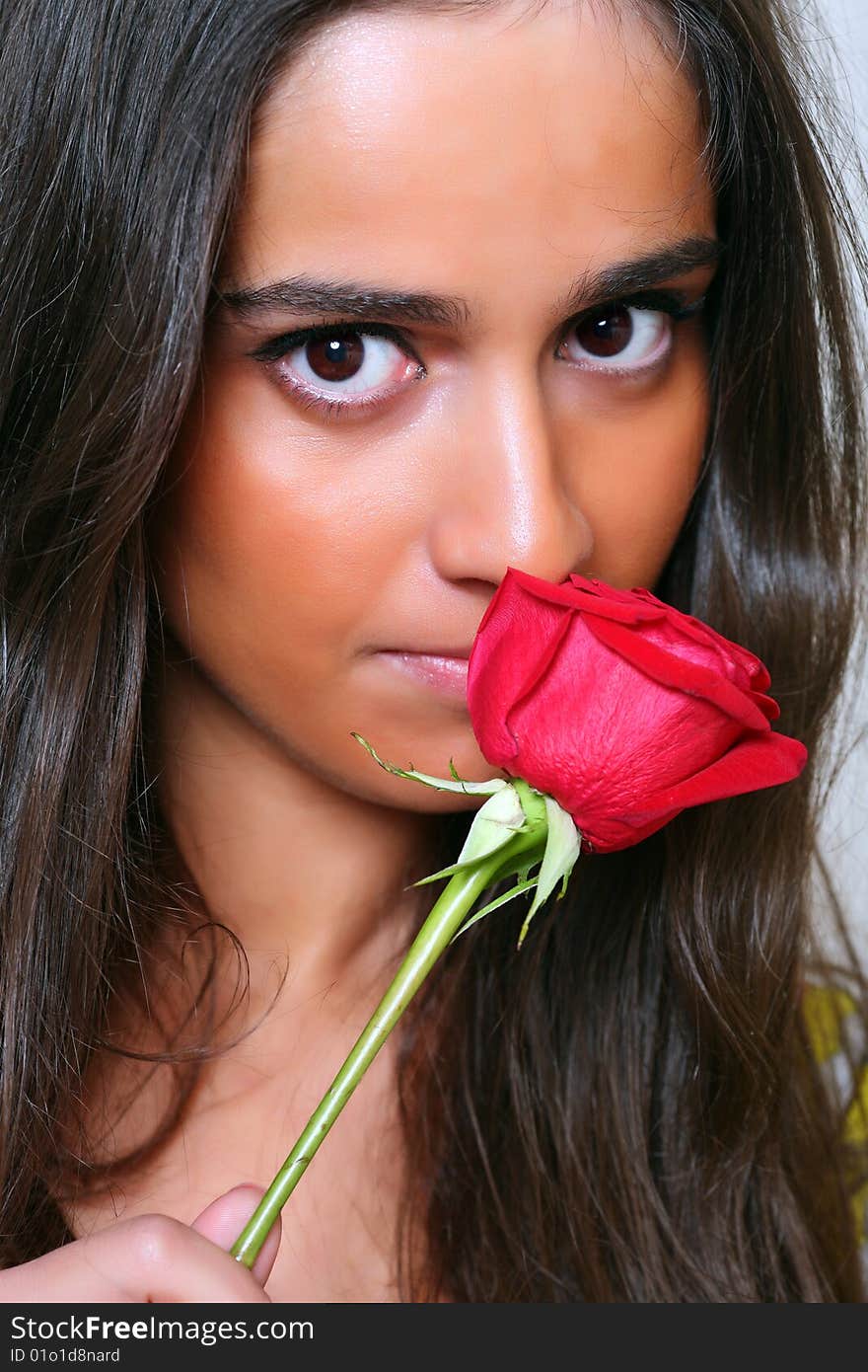 Portrait of the young beautiful woman with a red rose in hands. Portrait of the young beautiful woman with a red rose in hands