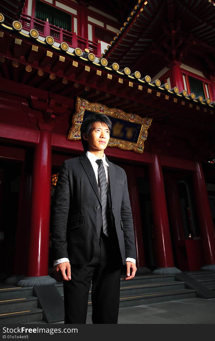 Asian man in business suit in chinese temple. Asian man in business suit in chinese temple