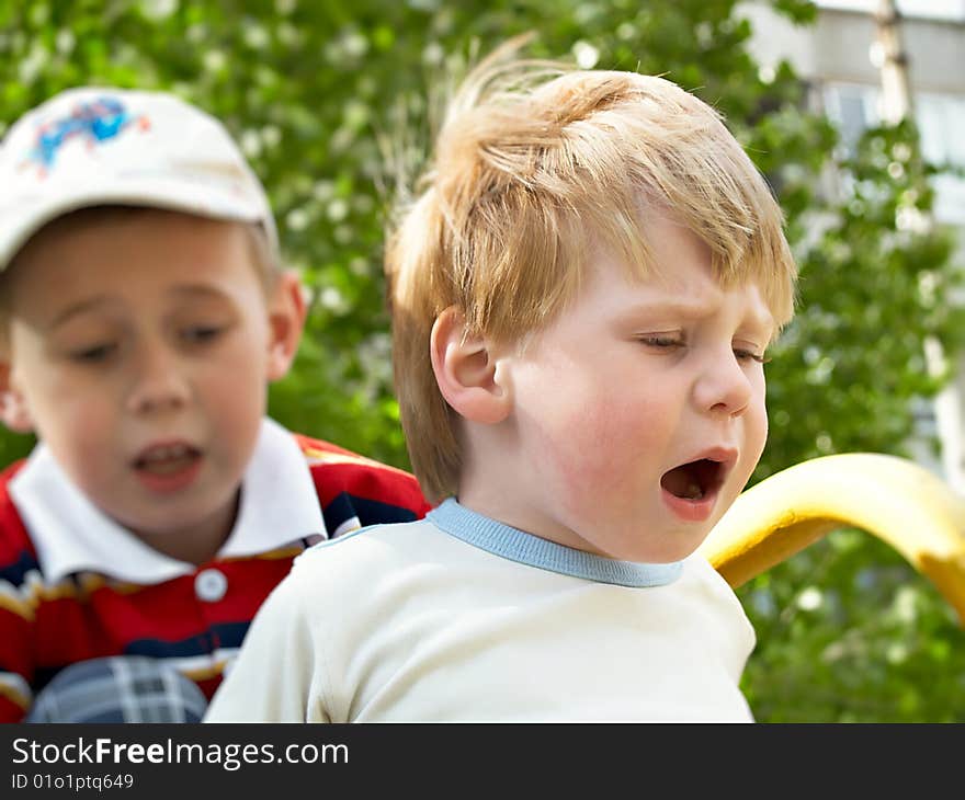 Boys play on a children's playground in the spring. Boys play on a children's playground in the spring