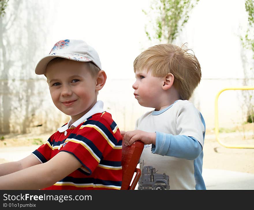 Boys play on a children's playground in the spring. Boys play on a children's playground in the spring