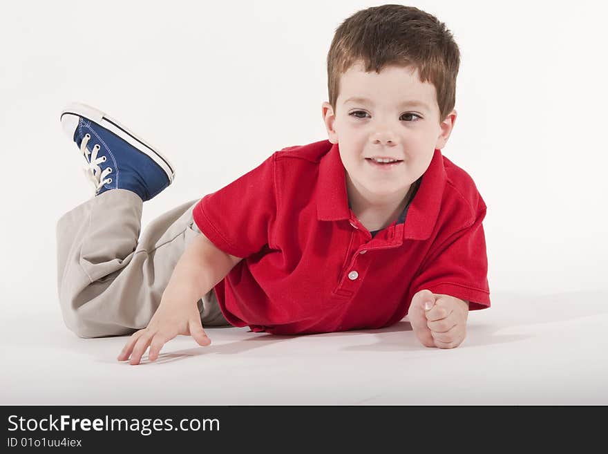 Young boy lying on floor looking happy. Young boy lying on floor looking happy