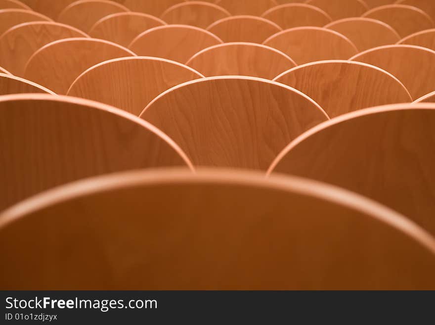 Close-up of empty cinema auditorium with line of wooden chairs.