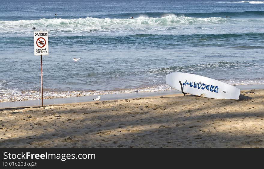 Danger sign on the beach beside a lifegua